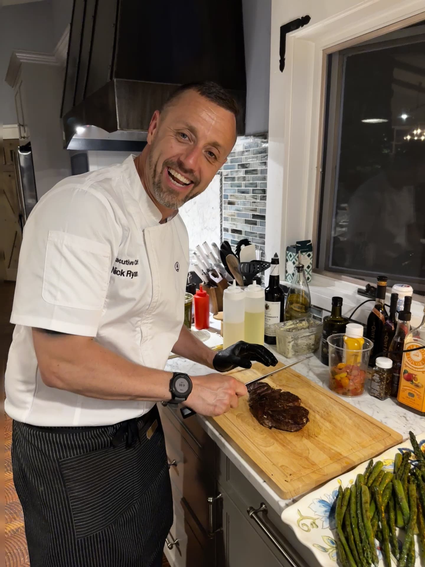 Executive Chef Nick Ryan slicing a hand-cut steak in the Red's Tavern kitchen at Watson's Lakefront Resort