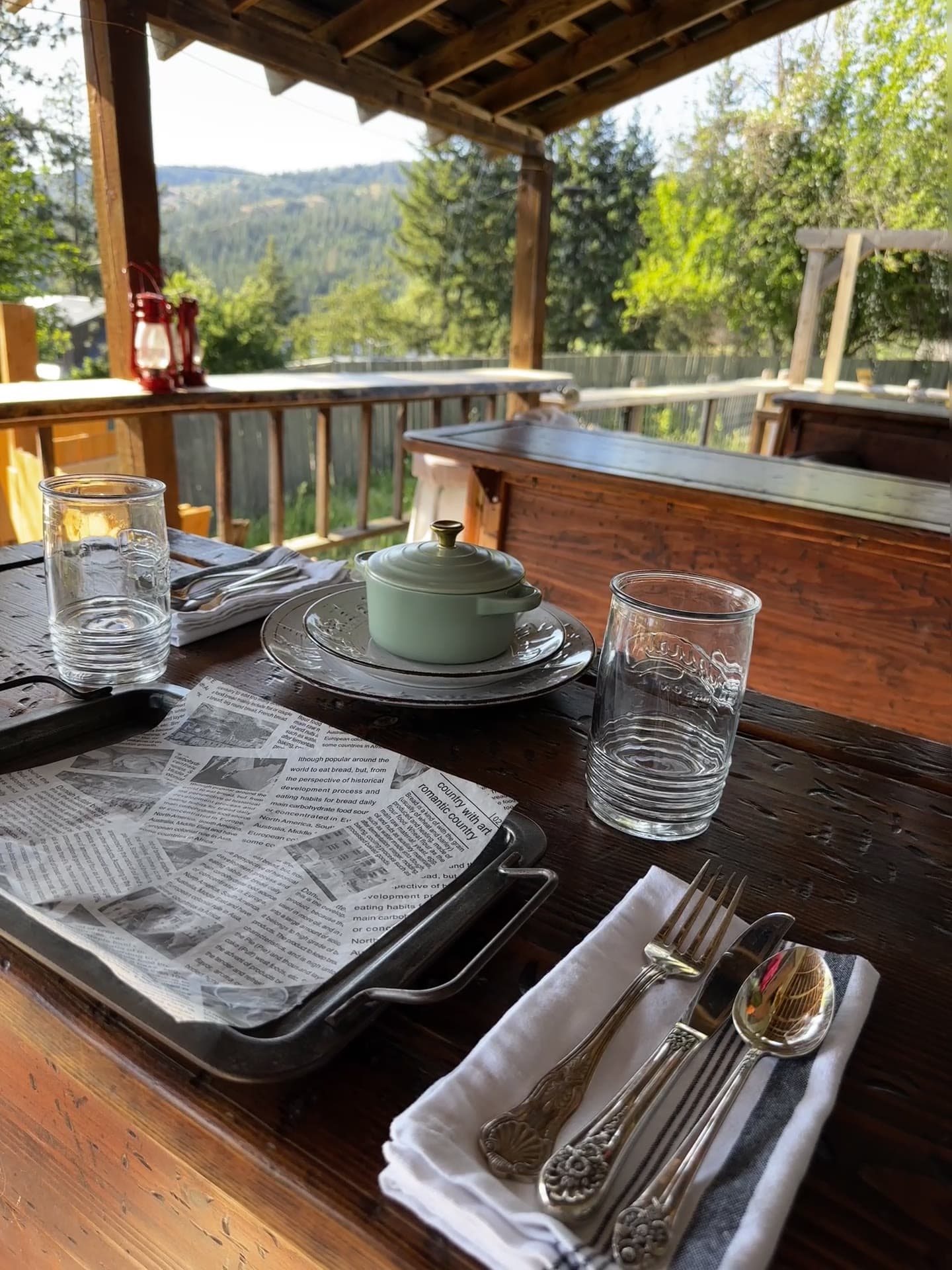 Red's Tavern lakefront deck set for breakfast with mountain views at Watson's Lakefront Resort